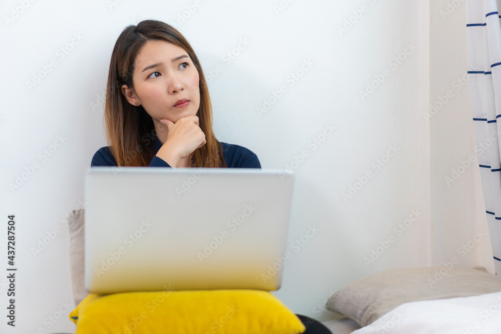 Concentrated Asian woman making decision or lack of idea working at home. Female trying to solve problems working at home while coronavirus pandemic Concentrated Asian woman making decision or lack of idea working at home. Female trying to solve problems working at home while coronavirus pandemic
