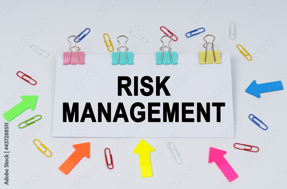 On the table there are paper clips and directional arrows, a sign that says - Risk Management On the table there are paper clips and directional arrows, a sign that says - Risk Management