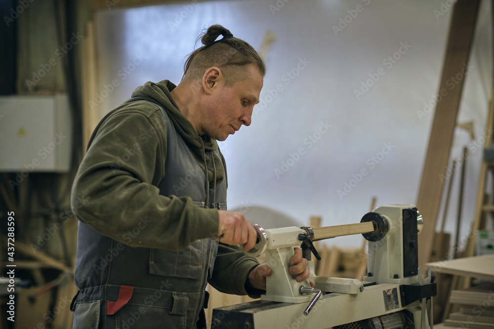 Woodwork and furniture making. Joinery, woodworking and furniture making, professional carpenter cutting wood in carpentry shop, industrial concept Woodwork and furniture making. Joinery, woodworking and furniture making, professional carpenter cutting wood in carpentry shop, industrial concept