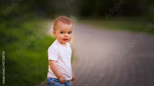 Portrait of a little boy in jeans and a t-shirt on the street