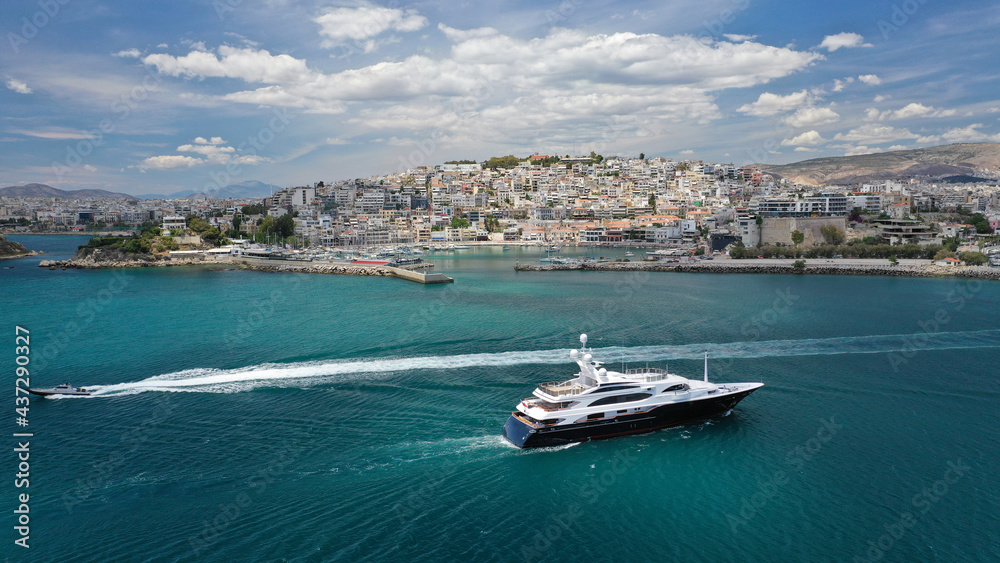 Aerial drone photo of luxury yacht cruising near beautiful round port of Mikrolimano or small port in the heart of Piraeus, Attica, Greece Aerial drone photo of luxury yacht cruising near beautiful round port of Mikrolimano or small port in the heart of Piraeus, Attica, Greece