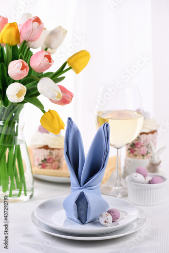 A napkin folded in the shape of a hare  rabbit   the concept of setting a festive table in honor of Easter.