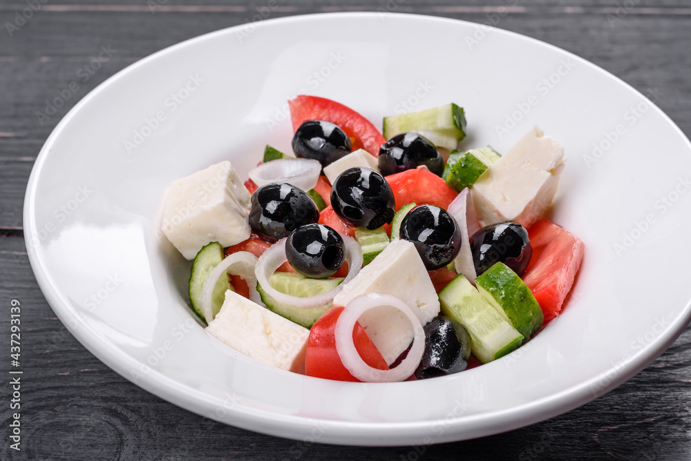 Fresh delicious Greek salad with tomato, cucumber, onions and olives with olive oil