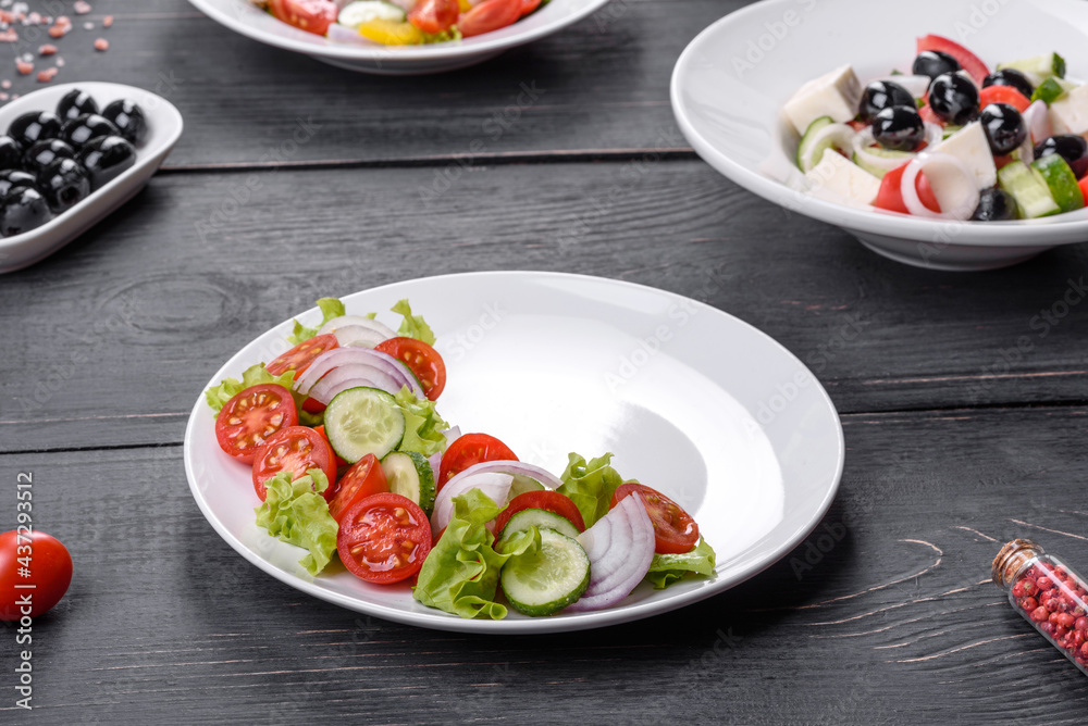 Fresh delicious salad with vegetables: tomato, cucumber, onions and greens with olive oil Fresh delicious salad with vegetables: tomato, cucumber, onions and greens with olive oil