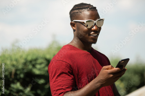 handsome young african man wearing sunglasses with mobile phone 