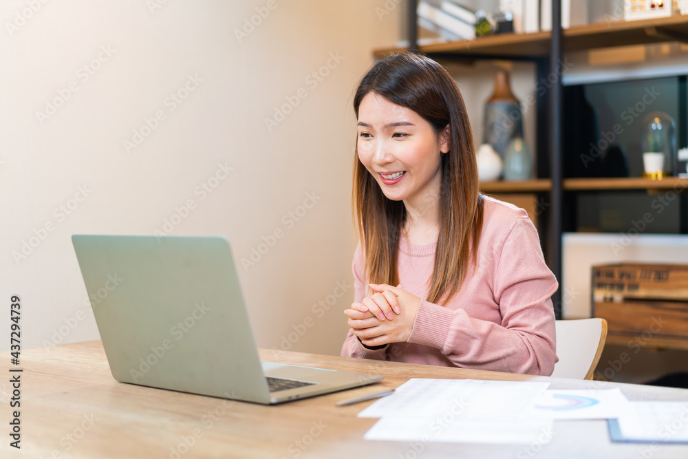 Asian woman using laptop making video call for distant meeting or online support working from home while coronavirus pandemic Asian woman using laptop making video call for distant meeting or online support working from home while coronavirus pandemic