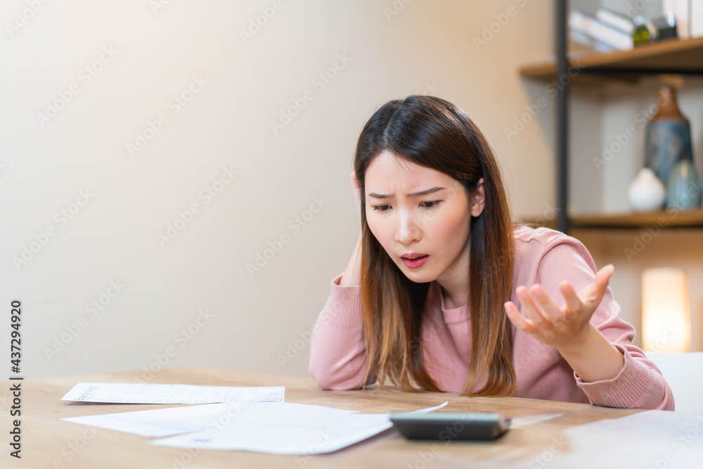 frustrated Asian woman looking at the paper bills upset throwing crumpled paper away. mental problems, failure reaction frustrated Asian woman looking at the paper bills upset throwing crumpled paper away. mental problems, failure reaction