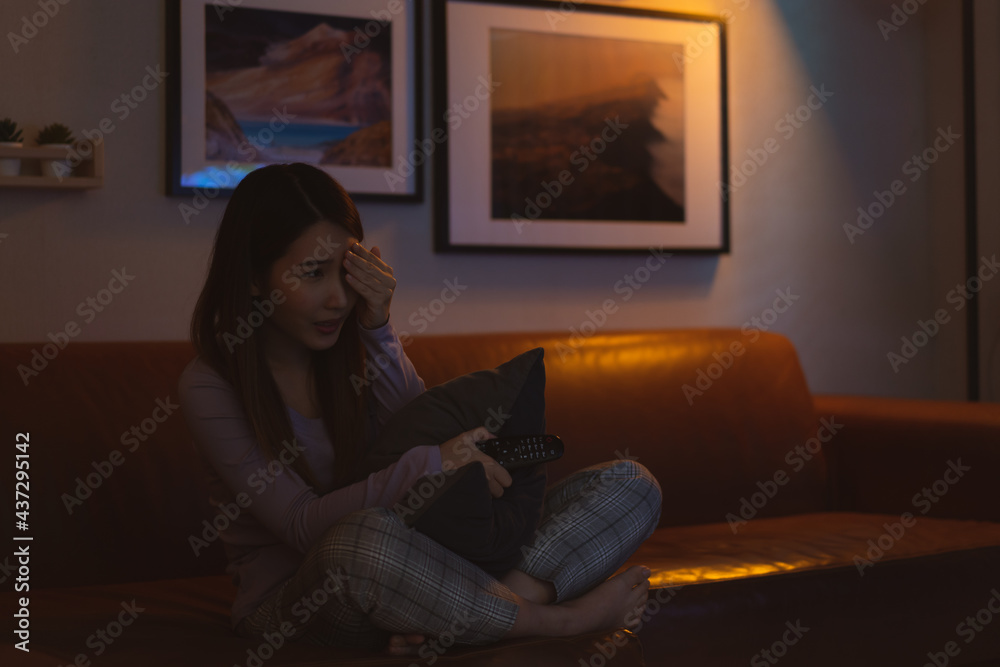 Asian woman watching horror movie scared at night Asian woman watching horror movie scared at night