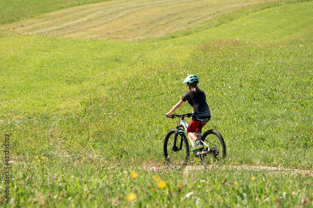 Girl child riding mountain bike on a green meadow in summer. Girl child riding mountain bike on a green meadow in summer.
