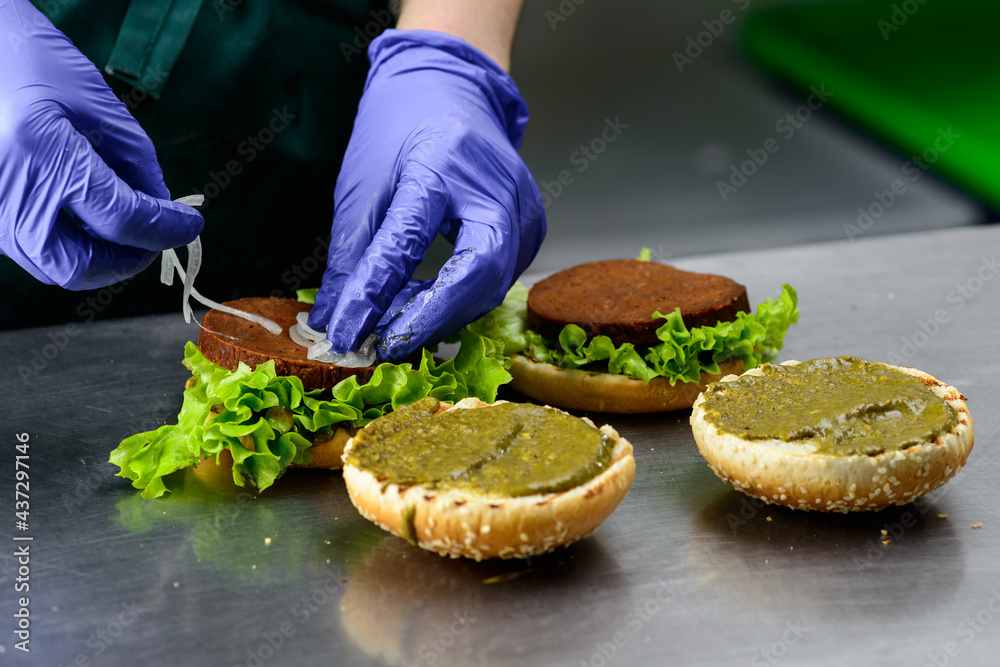 Unidentified chef preparing appetizing burgers Unidentified chef preparing appetizing burgers