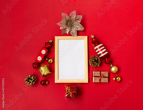 Flat composition with a Christmas tree made of different festive items, snowflakes, gifts, sweets, Christmas tree decorations on a red background. mockup. Copy space.