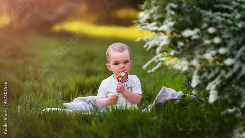 Child eating gingerbread in the grass in summer