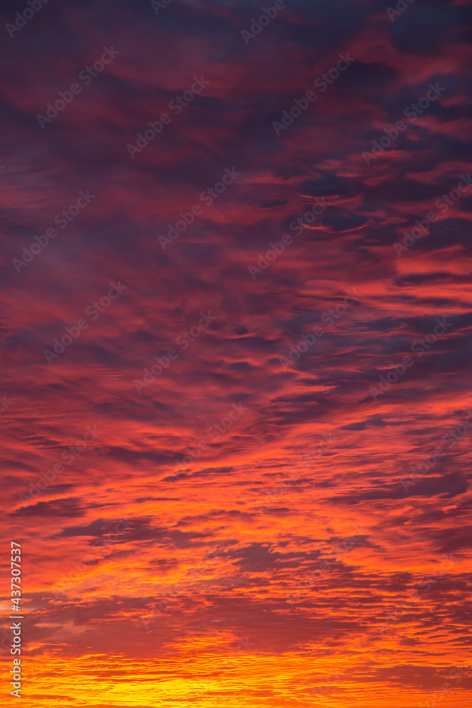 Epic Dramatic bright sunrise, sunset orange red sky with clouds in sunlight background texture