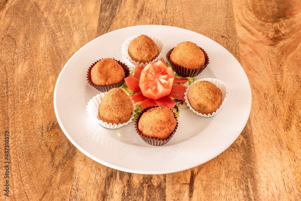 delicatessen croquettes of jerky and Iberian ham accompanied by a tomato flower served as chocolates delicatessen croquettes of jerky and Iberian ham accompanied by a tomato flower served as chocolates