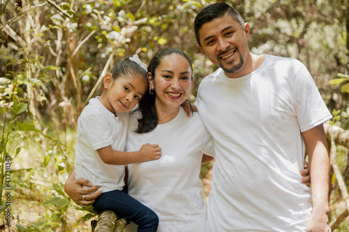 Hispanic parents with their daughter in the park - happy little family - young parents #437311348