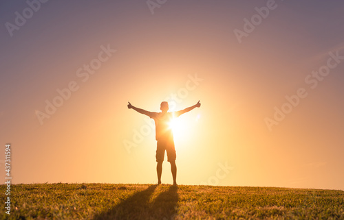 Silhouette of happy young man with fist up tot he sky. People feeling positive, and winning concept. 