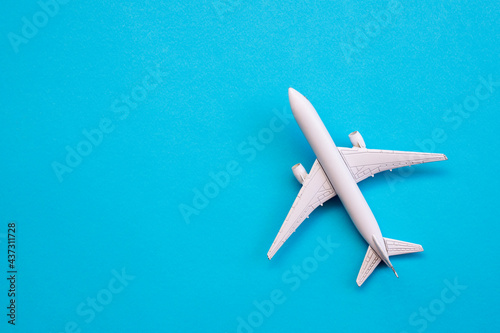 Flat lay design of travel concept with plane on blue background with copy space. © Hazal