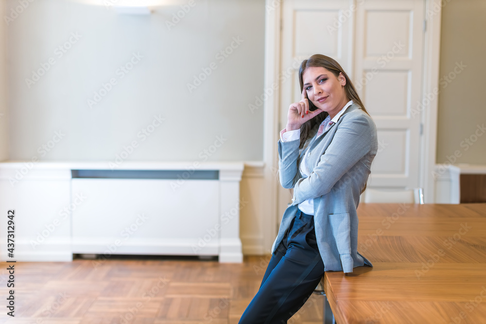 young businesswoman leaning on table in her office young businesswoman leaning on table in her office