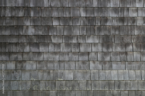 Wet aged weathered cedar shingle siding texture on an old summer cottage home building