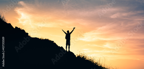Freedom, happiness and adventure in nature. Happy man on a mountain with arms up to the sky. 