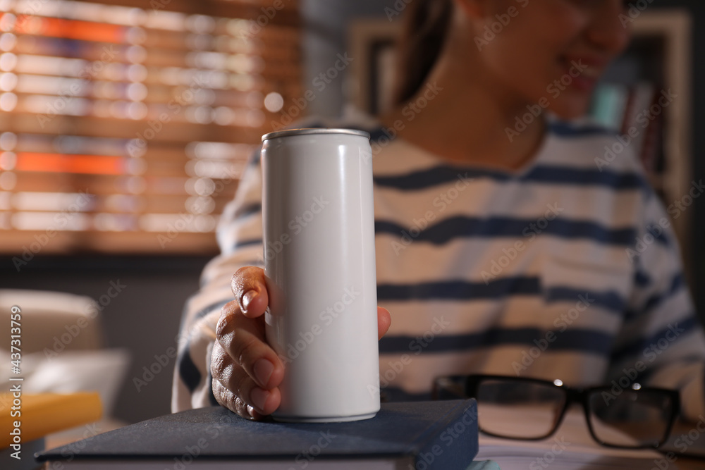 Young woman with energy drink studying at home, closeup - obrazy, fototapety, plakaty 