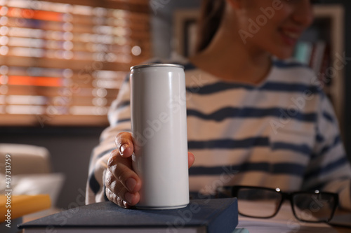 Young woman with energy drink studying at home, closeup