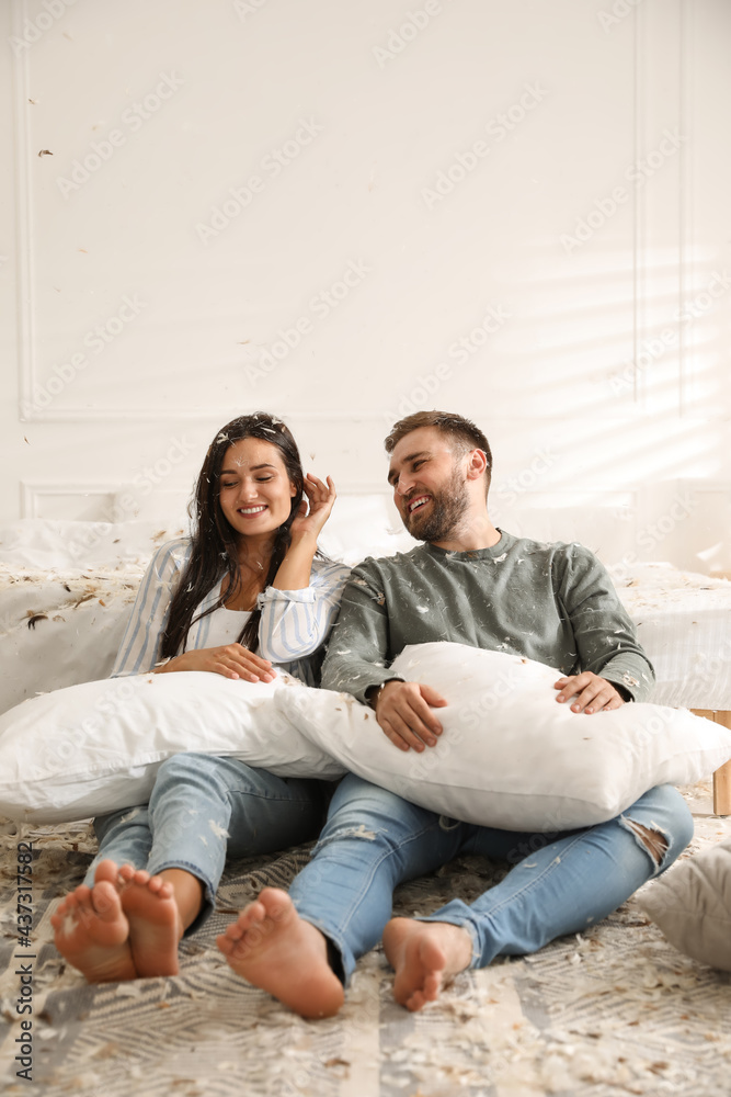 Happy young couple resting after fun pillow fight in bedroom Happy young couple resting after fun pillow fight in bedroom