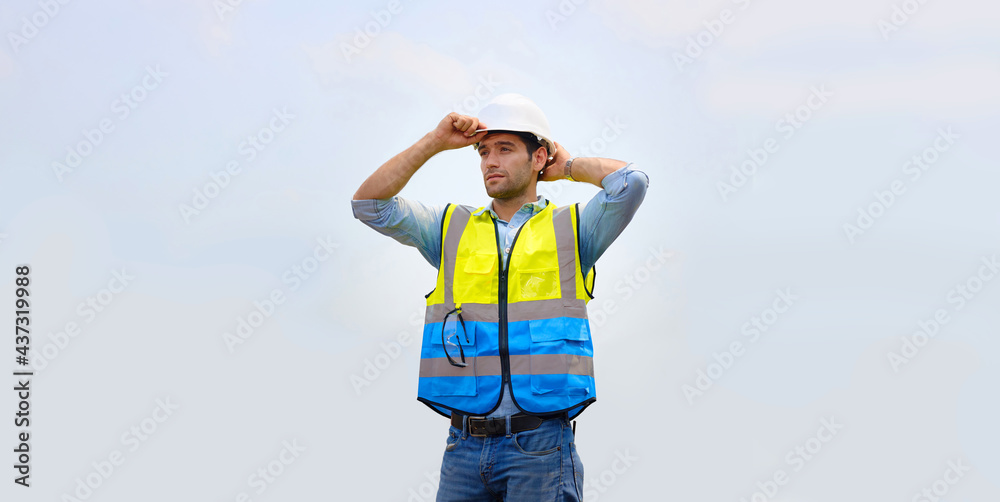Caucasian male engineer or architect wearing helmet stands outdoors. Caucasian male engineer or architect wearing helmet stands outdoors.