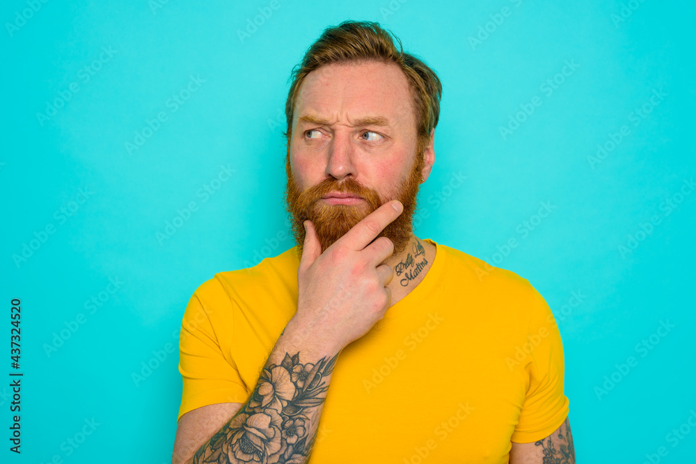 Man with yellow t-shirt and beard is very undecided Man with yellow t-shirt and beard is very undecided