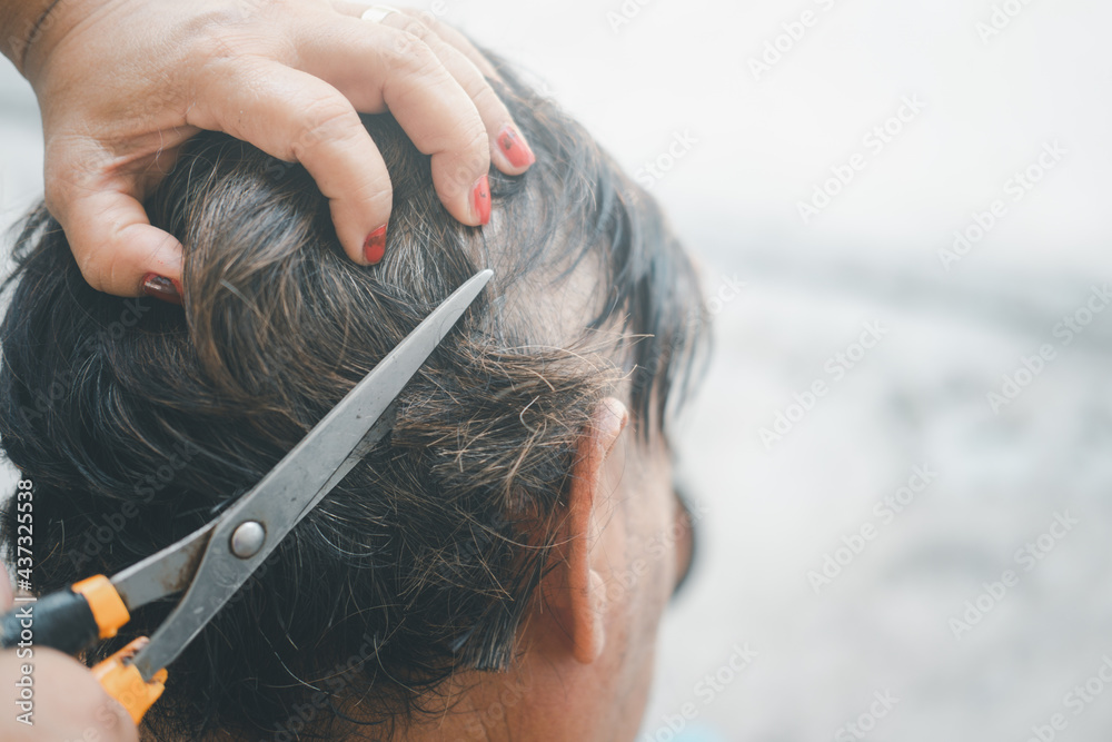 Obraz premium Wife cuts her husband's hair at home in a pandemic situation.