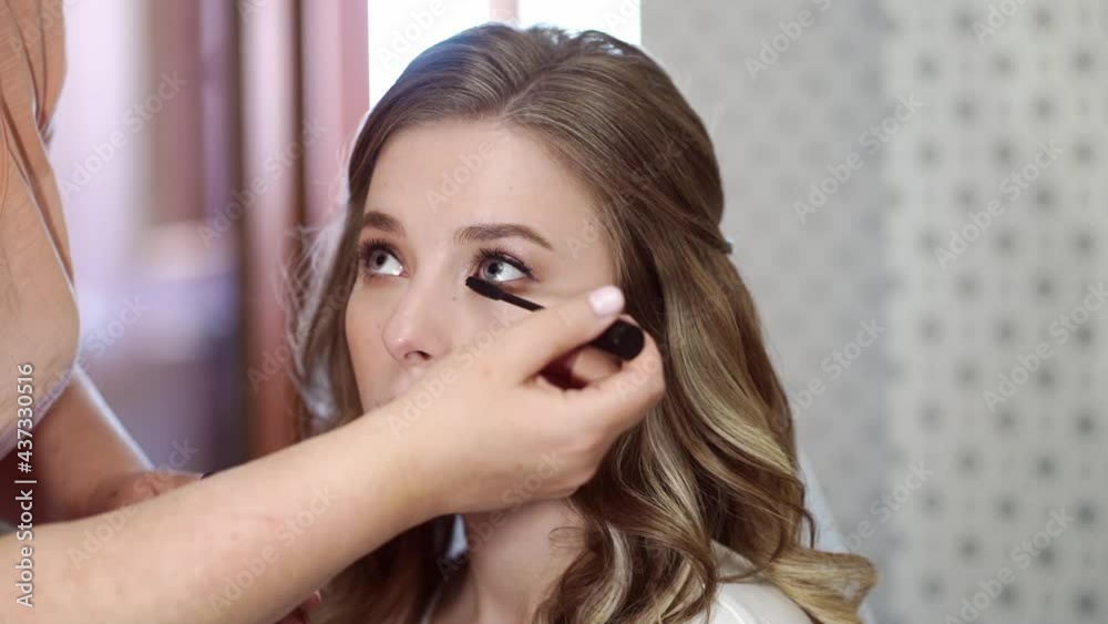 A beautiful girl with long hair do eye makeup. A beautiful girl with long hair do eye makeup.