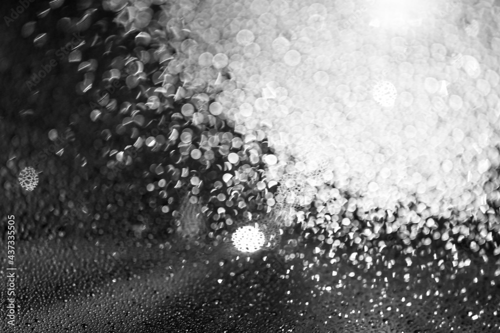 Water droplets on glass at night, dark background. Black and white texture. Defocus and blur. High quality photo Water droplets on glass at night, dark background. Black and white texture. Defocus and blur. High quality photo