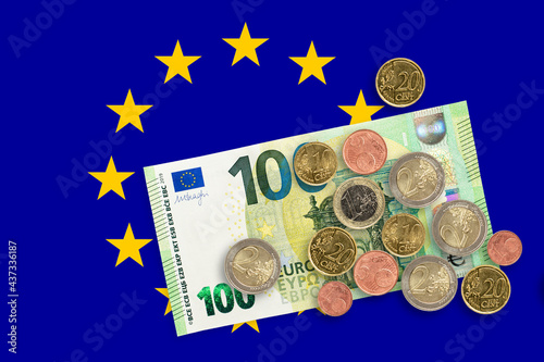 Currency of European Union over European Economic Community Flag. EUR is the official currency of the European Union photo