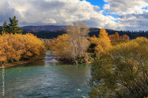 The Clutha River in the South Island of New Zealand, surrounded by colorful autumn foliage 
