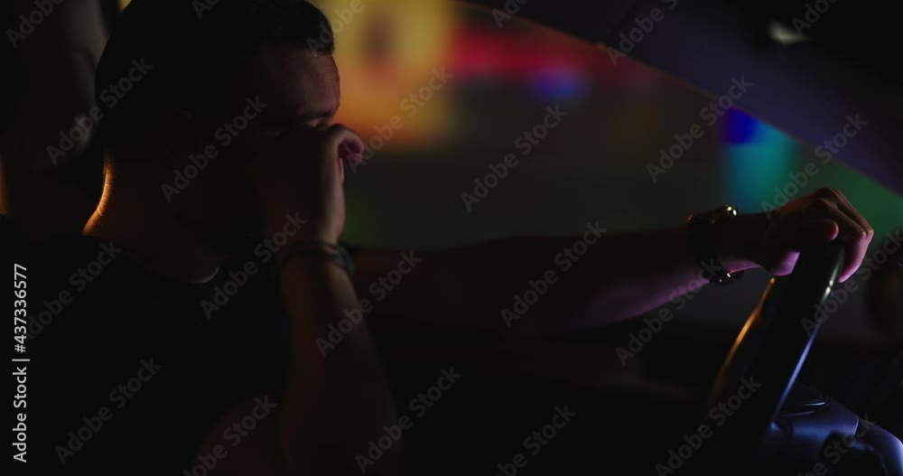 Hombre triste conduciendo de noche por la ciudad