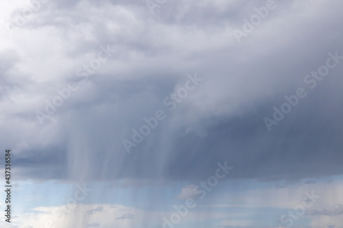 a blue sky with dark storm clouds. Rain clouds are gathering and a thunderstorm is coming. © 1take1shot