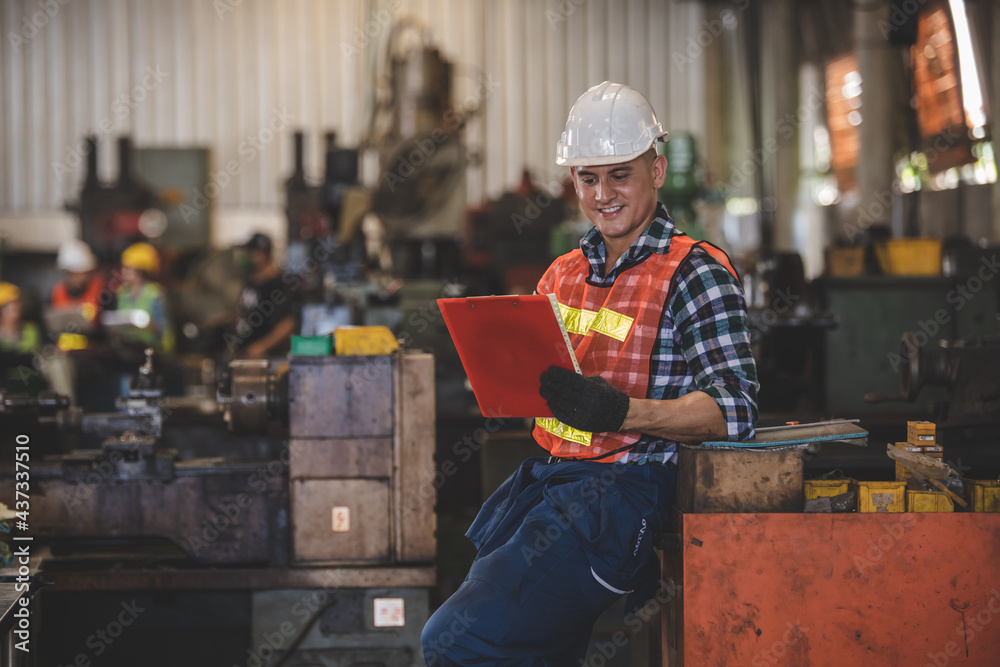 man Lathe worker in production plant drilling at machine on the factory. Industrial engineer worker holding notebook Inspect workpieces man Lathe worker in production plant drilling at machine on the factory. Industrial engineer worker holding notebook Inspect workpieces