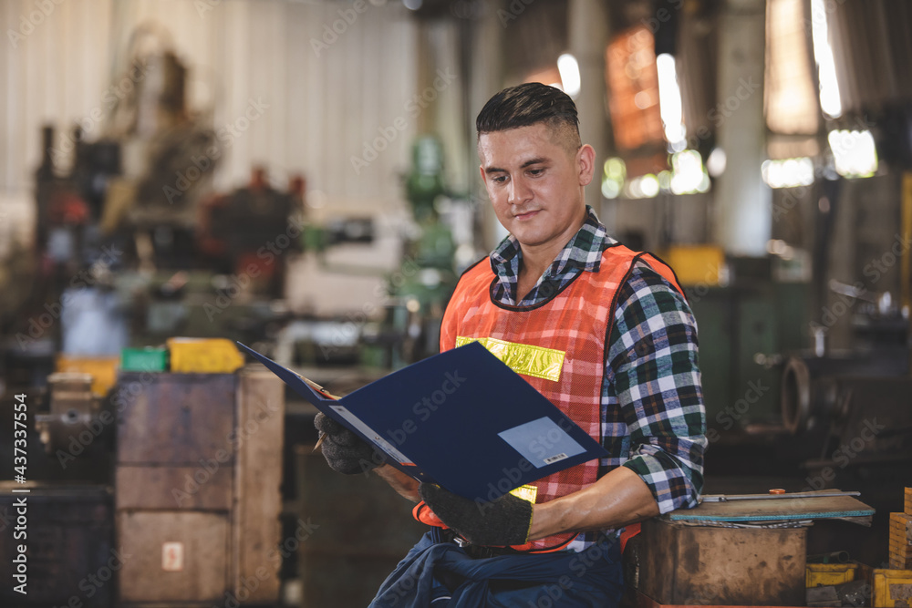man Lathe worker in production plant drilling at machine on the factory. Industrial engineer worker holding notebook Inspect workpieces man Lathe worker in production plant drilling at machine on the factory. Industrial engineer worker holding notebook Inspect workpieces