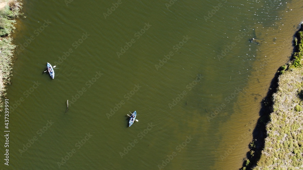 overhead aerial view of 2 people fishing in a murky river from their kayaks on a sunny day, Werribee river, Victoria, Australia overhead aerial view of 2 people fishing in a murky river from their kayaks on a sunny day, Werribee river, Victoria, Australia