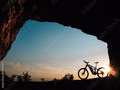 silhouette of a e-bike or bike at sunset in a cave