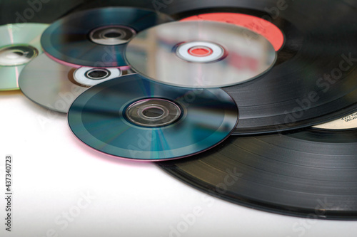 vinyl discs and CDs on a white surface concept storage of information progress