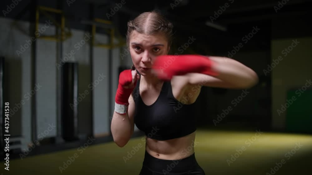 Female fighter trains his punches, training in the boxing gym, young woman looks at the camera and trains a series of punches, 4k slow motion. Female fighter trains his punches, training in the boxing gym, young woman looks at the camera and trains a series of punches, 4k slow motion.