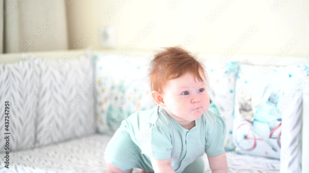 Baby with red hair crawls in his crib Baby with red hair crawls in his crib