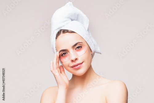 Young woman applying eye patches. Beautiful girl with silicone eye patches. Facial care at home. Girl with clean skin. Young beautiful girl using patches under the eyes.