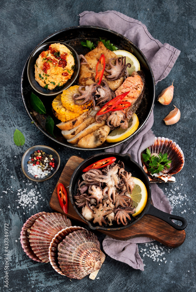 Grilled seafood variety with vegetables on dark background. Grilled seafood variety with vegetables on dark background.