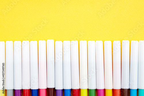 Top view of multicolored pointed markers isolated on yellow background