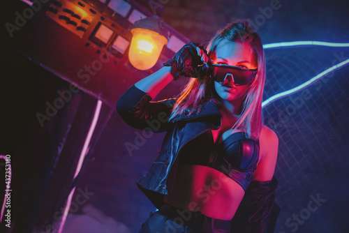 Young cyberpunk style girl in the neon lights concept.