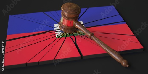 Block with flag of Haiti hit by judge's gavel. Court related 3d rendering
