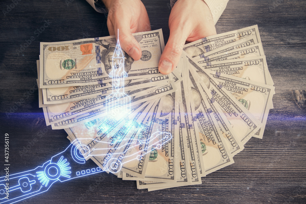 Multi exposure of creative drawing hologram and USA dollars bills and man hands. Start up concept Multi exposure of creative drawing hologram and USA dollars bills and man hands. Start up concept