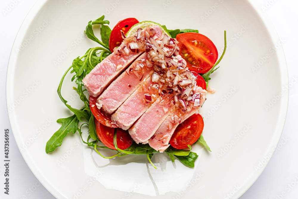 tuna fillet with salad on white plate